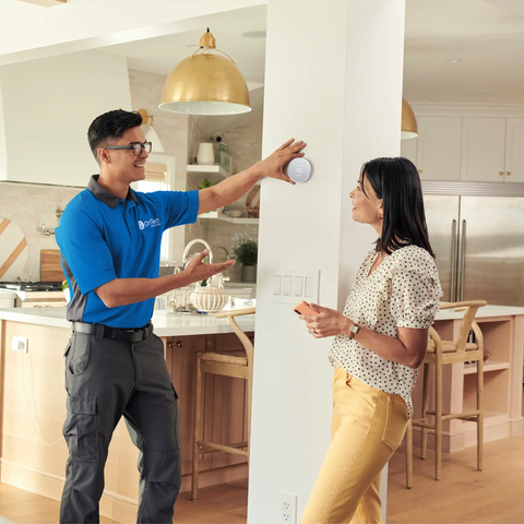 OnTech installing a smart thermostat in a kitchen